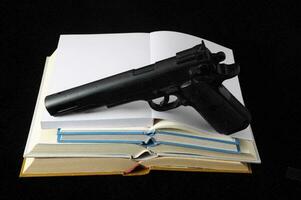 pistola con libri foto