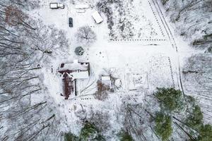 aereo panoramico inverno Visualizza di villaggio con case, fienili e ghiaia strada con neve foto