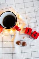 Due tazze di caffè nel rosso tazze su un' sfondo di cioccolato canfet nel il modulo di un' cuore. mattina sorpresa per San Valentino giorno. Visualizza a partire dal sopra. foto