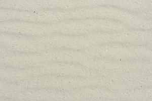 sabbioso sfondo con onde. naturale sfondo. vento soffiato sabbia struttura. foto