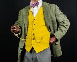uomo nel Vintage ▾ completo da uomo e pelle guanti Tenere tasca guarda. concetto di classico e eccentrico Britannico signore foto