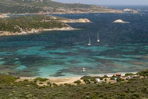 un' turchese blu mare e bianca sabbia spiaggia con rocce nel sardegna Italia foto