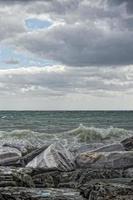 mare nel tempesta su rocce foto