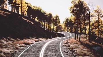 strada e giallo montagna foresta a tramonto foto