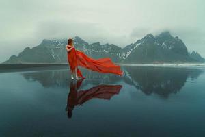 signora avvolto con rosso tessuto su reynisfjara spiaggia panoramico fotografia foto