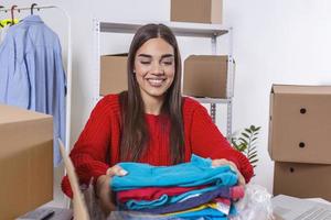 giovane donna, proprietario di piccolo attività commerciale Imballaggio Prodotto nel scatole, preparazione esso per consegna. donne Imballaggio pacchetto con sua prodotti quello lei vendita in linea foto