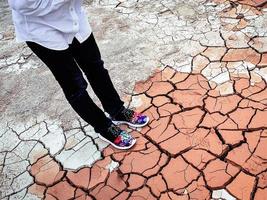 un' signora nel colorato scarpe in piedi su secco argilla foto