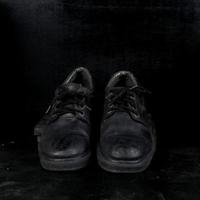 paio di nero maschio classico scarpe su nero sfondo. polveroso scarpe foto