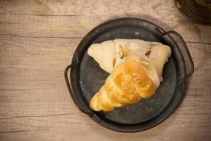 eleganti pasticcini in corno di crema francese in vassoio vintage su tavola di legno foto