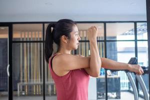 asiatico donne indossare abbigliamento sportivo in piedi, allungamento braccia, preparazione muscoli per allungare per preparare il corpo per essere pronto per esercizio. Salute e fitness concetto foto