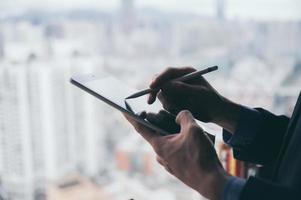 uomo d'affari che lavora con tablet con lo sfondo della città foto