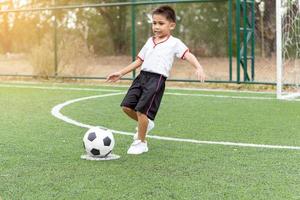 piccolo ragazzo che gioca a calcio foto