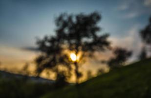 sfocato sfondo con il raggi di il sera sole foto