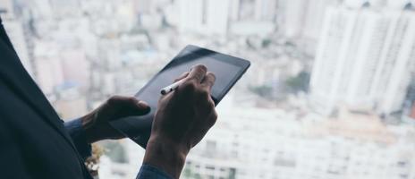 uomo d'affari che lavora con tablet con lo sfondo della città foto