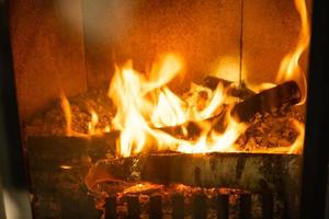 legna da ardere è ardente nel il forno di il focolare avvicinamento. alternativa eco-friendly il riscaldamento, caldo accogliente camera a casa, ardente legna foto