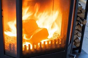 carburante bricchette fatto di premuto segatura per accendendo il forno - economico alternativa eco-friendly carburante per il camino nel il Casa. legna da ardere è ardente nel il forno nel il interno foto