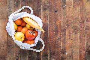 superiore Visualizza di ecologico bianca biancheria Borsa di maturo fruitson vecchio di legno tavolo. foto