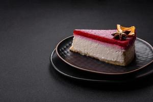 delizioso dolce torta di formaggio con lampone marmellata su un' nero ceramica piatto foto