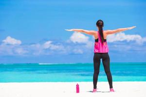 donna che fa yoga su una spiaggia foto