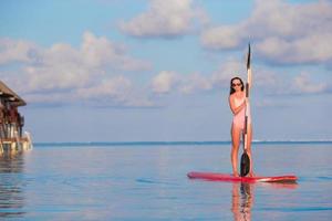 donna in piedi su paddleboarding