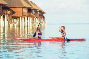maldive, asia meridionale, 2020 - due ragazze che fanno paddleboarding in un resort