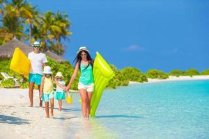 famiglia di quattro persone in vacanza al mare foto