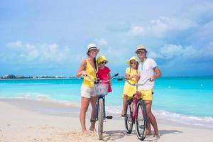 famiglia sulla spiaggia con le biciclette foto