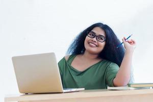 donna sorridente che lavora al suo computer portatile foto