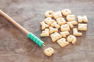 biscotti alfabeto con una matita foto