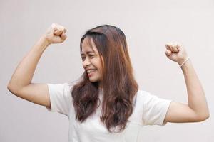 asiatico donne flettere loro muscoli e mostrare loro forza. foto