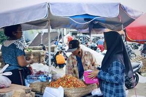 foto di parecchi persone fare acquisto e vendita attività nel il kumbasari mercato la zona.