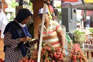 badung bali gennaio 13 2023 un' acquirente è visto acquisto fresco frutta e verdure a un' tradizionale mercato nel bali foto