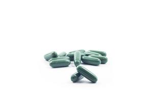 mucchio di pillole verdi su sfondo bianco