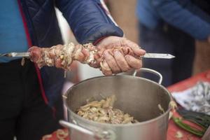 mettendo carne su coltello. cucinando carne con il tuo mani. strada cibo. popolare caucasico cucina. foto