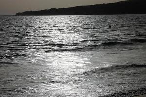 solitario, poco affollato spiaggia con calma mare e piccolo onde foto