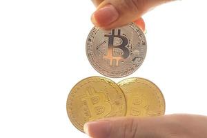 mano detiene tre monete di digitale moneta bitcoin foto