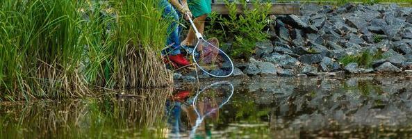 un' ragazzo con un' netto catturare pesce foto