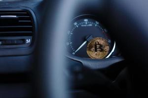 moneta è un' oro bitcoin su il pannello di controllo di il auto Il prossimo per il carburante consumo foto