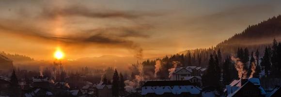 inverno Alba sopra il montagna villaggio coperto con fresco mattina neve foto