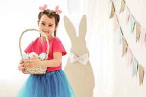 carino poco ragazza con coniglietto orecchie e cestino di Pasqua uova foto
