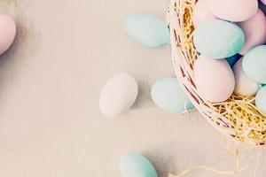 uova di Pasqua in nido sul colore di sfondo in legno foto