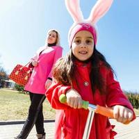 bambino equitazione scooter su modo indietro per scuola. poco ragazza giocando all'aperto apprendimento per equilibrio su calcio tavola. bambini cavalcata scooter nel periferia strada. bambino in età prescolare nel sicuro casco su bicicletta o rullo. foto