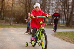 bambini equitazione biciclette nel un' parco foto