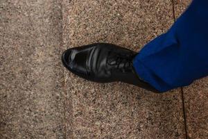 giovane moda dell'uomo gambe nel Marrone stivali su pavimento foto