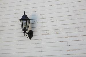 lanterna nel il neve su un' grigio di legno parete. foto