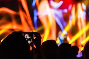 un' smartphone tenuto con Due mano nel ordine per sparare un' metraggio durante un' concerto. foto