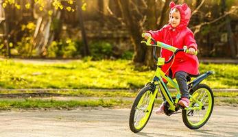 padre insegnamento il suo figlia per cavalcata un' bicicletta foto