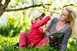 contento famiglia. madre e figlia siamo apprendimento per scrivere. adulto donna insegna bambino il alfabeto. foto