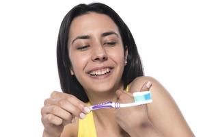 contento giovane donna con salutare denti Tenere un' dente spazzola foto