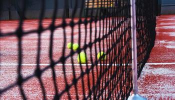 tennis racchette con tennis palle su argilla Tribunale foto